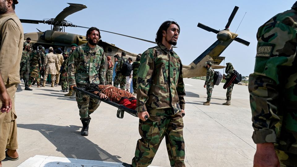 Taliban security personnel carry an earthquake victim evacuated by a military helicopter from the Nurgal district after her arrival for medical assistance in Jalalabad on Monday. - Wakil Koshar/AFP/Getty Images