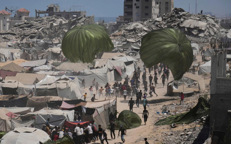 Palestinians rush to collect humanitarian aid airdropped by parachutes into Gaza City in early August - Jehad Alshrafi/AP