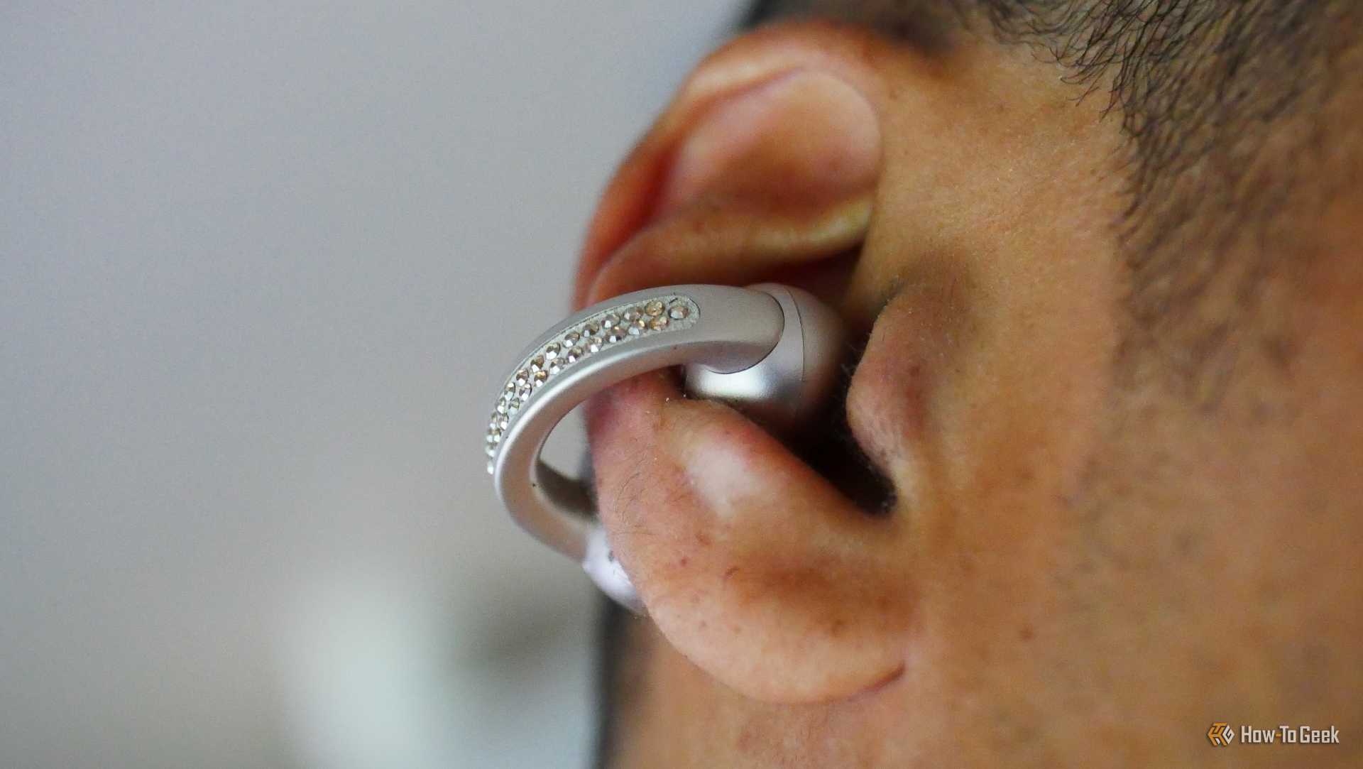 A ear wearing a Moto Buds Loop earbud.