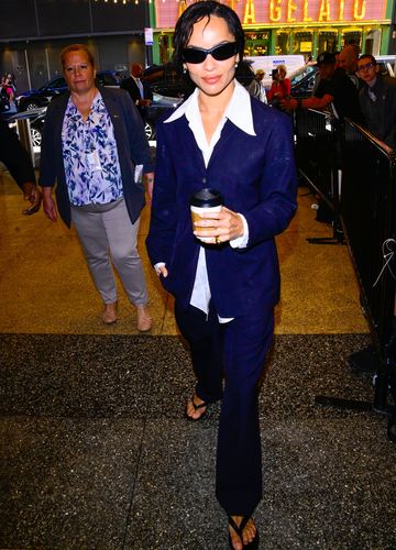 Zoë Kravitz in einem dunkelblauen Hosenanzug mit einer weißen Bluse