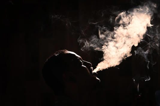 A man exhales smoke from a cigarette