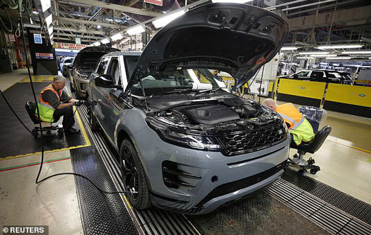 Staff are seen assembling Range Rover Evoque SUVs on the production line at Jaguar Land Rover's Halewood factory in Liverpool in December 2022 - the plant was closed on Monday