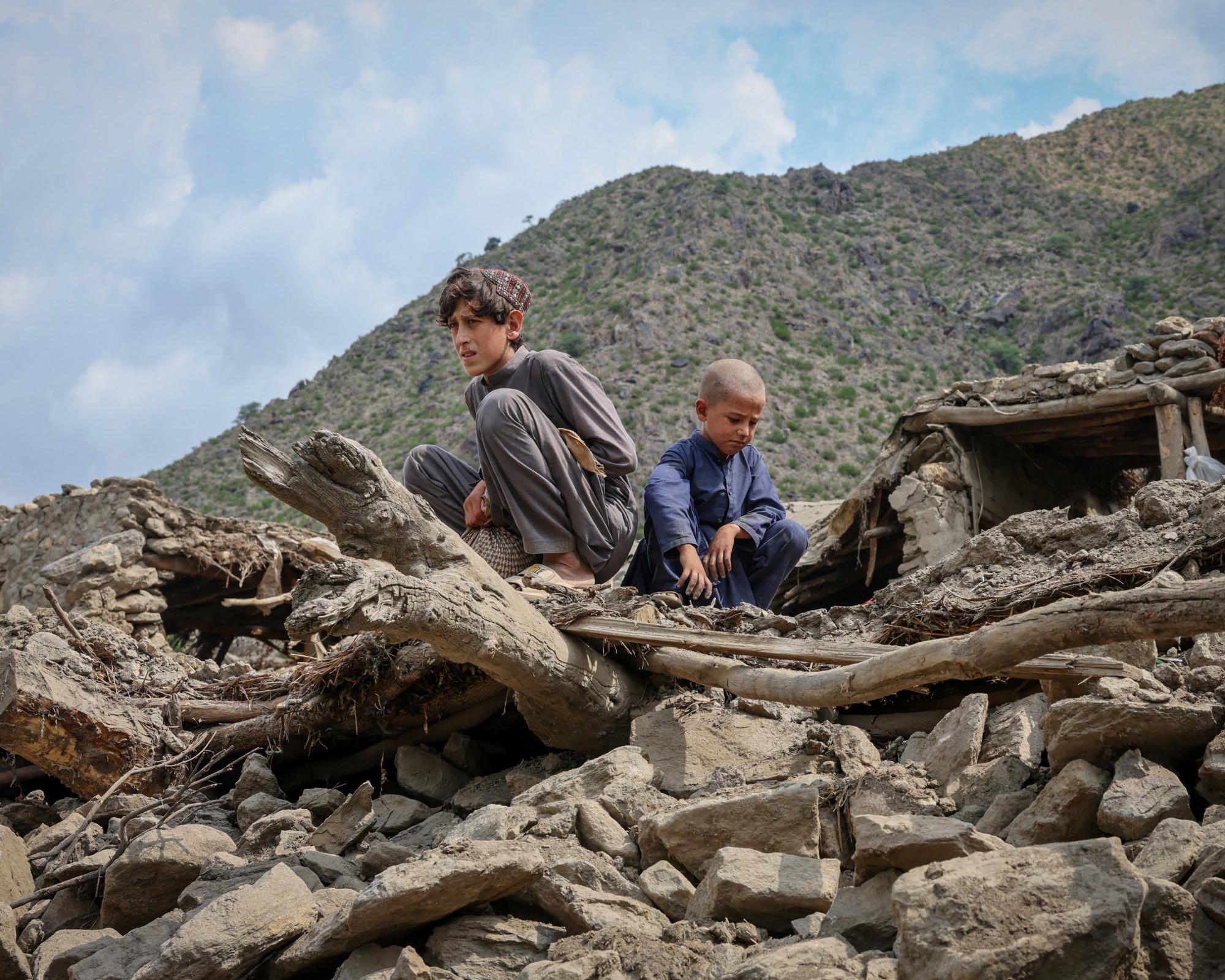 Two boys sit on the rubble of a house destroyed by Sunday’s earthquake in Kunar province, Afghanistan. Photograph: Sayed Hassib/Reuters