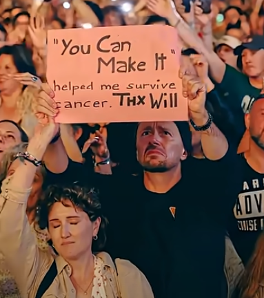 A woman's headband seems to go over the wrist of the woman in front, while her own hand morphs into the man holding up a sign (YouTube/Will Smith)