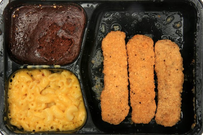 frozen microwaveable “tv dinner” “Chicken Fingers Meal” with “Breaded Chicken Patties”, “Macaroni & Cheese Sauce”, and a “Fudge Brownie” isolated on white with room for your text
