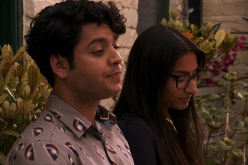 A brother and sister sitting on a bench