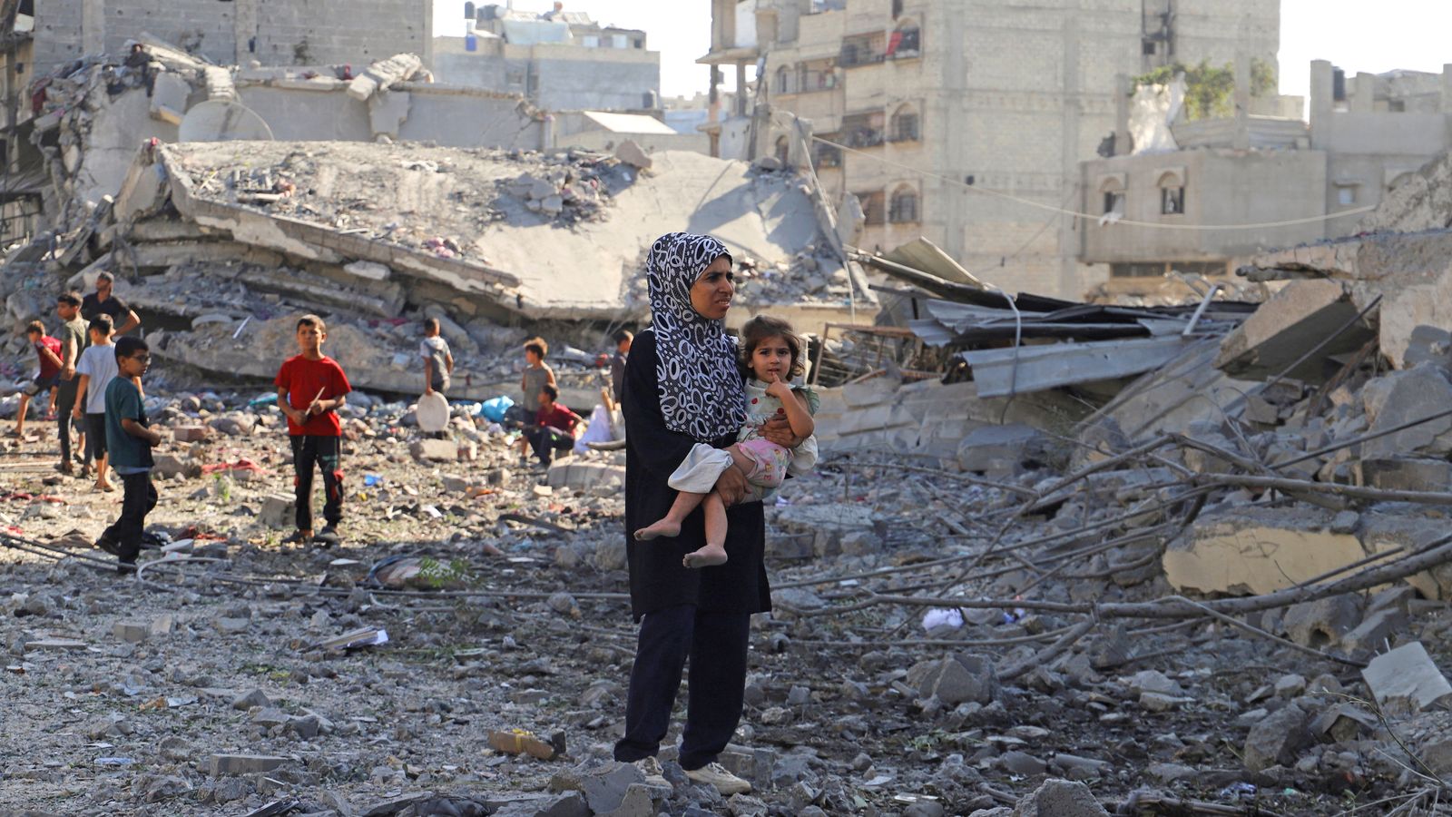 A Palestinian woman and a child inspect the site of an overnight Israeli strike in Gaza City. Pic: Reuters