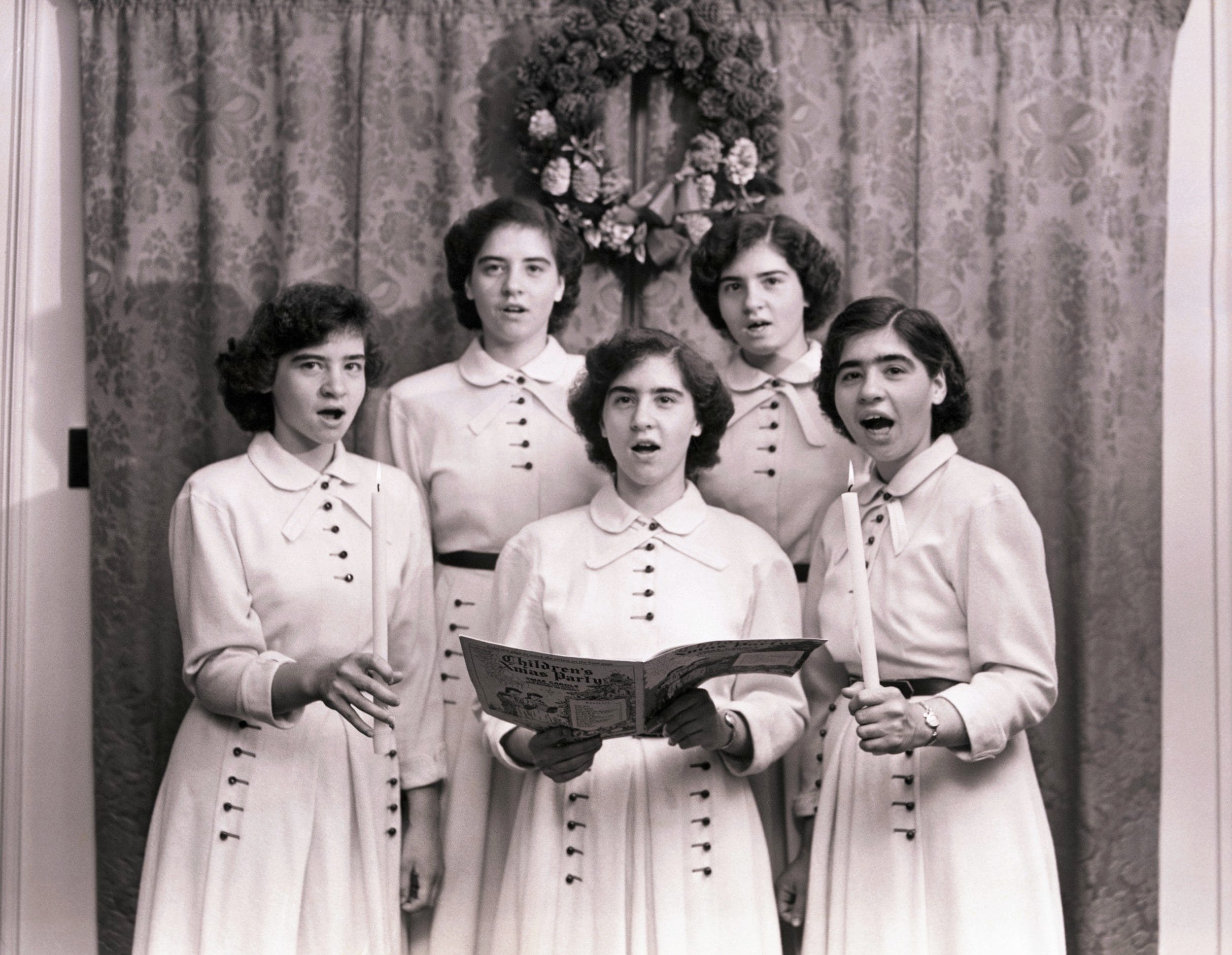 The Dionne quintuplets singing Christmas carols. Left to right, Yvonne, Cecile, Marie, Annette and Emilie