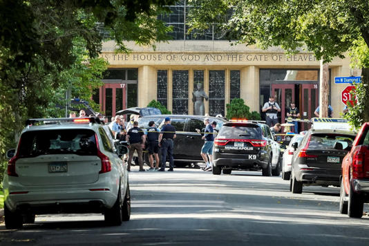 Officers gather outside Annunciation Church following a mass shooting event (Picture: REUTERS)