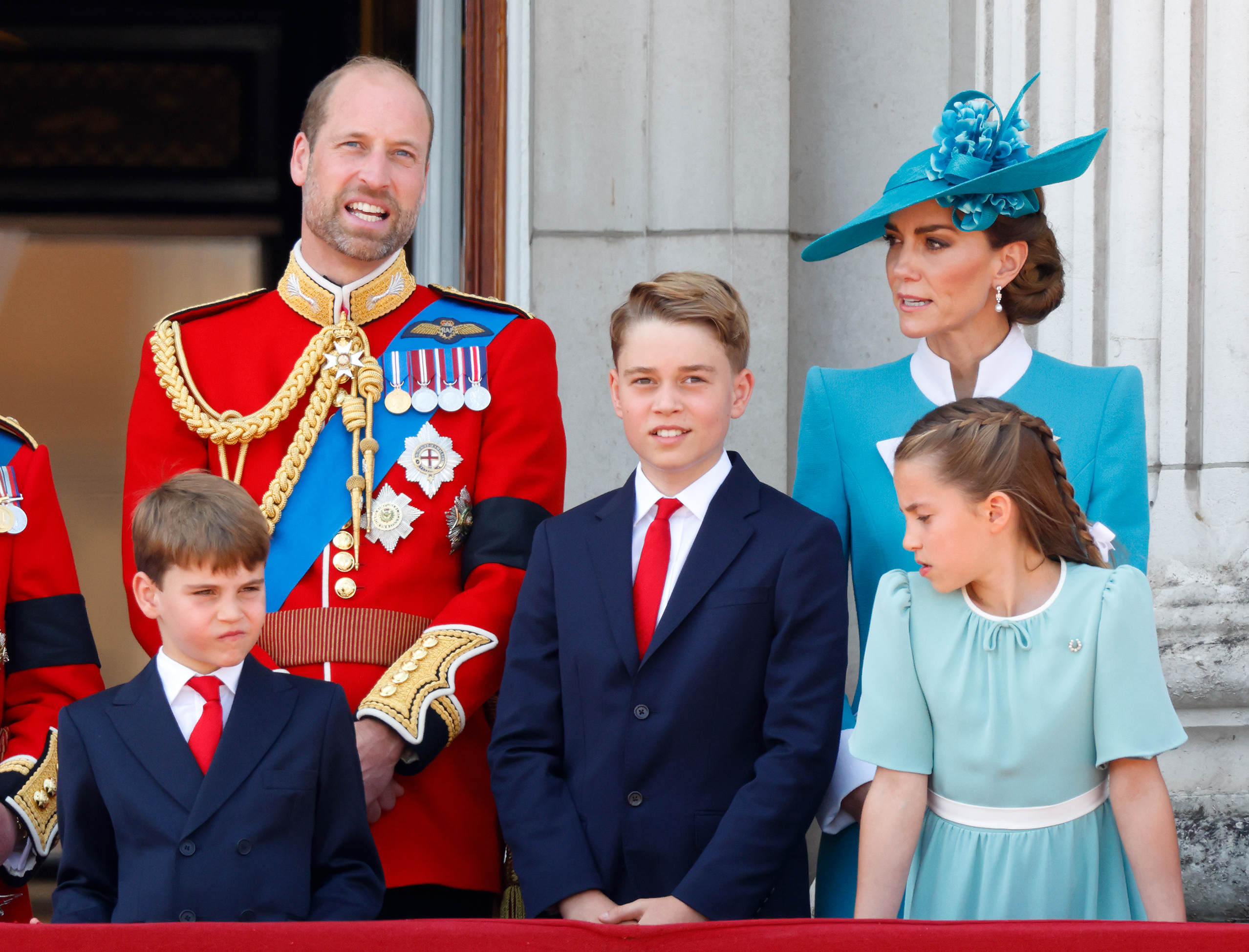 Prince William, Prince George, Princess Kate, Prince Louis and Princess Charlotte in suits and blue dresses on the balcony of Buckingham Palace