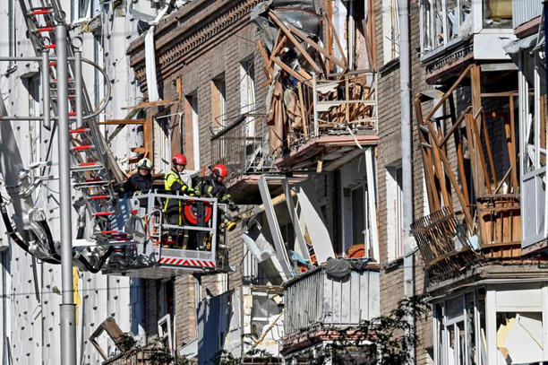Serviços de emergência inspecionam um prédio atingido por um bombardeio russo em Kiev Foto: Sergei Supinsky/AFP