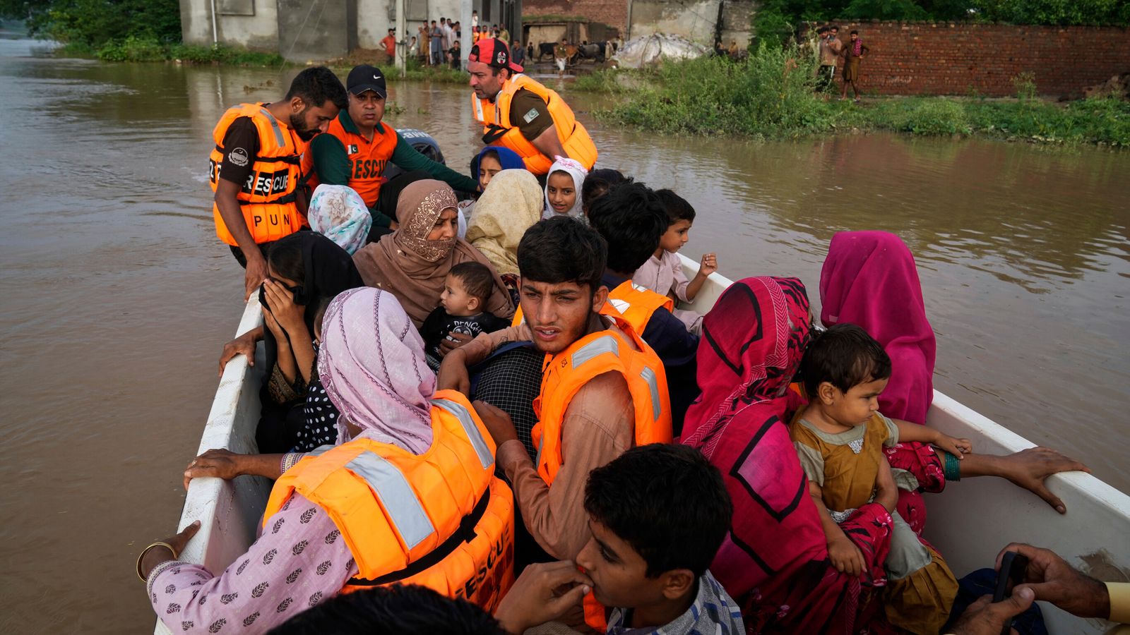 Rescue workers evacuate villagers from a flooded area in Chango Walia village in Narowal district, Pakistan Pic: AP/K.M. Chaudary.
