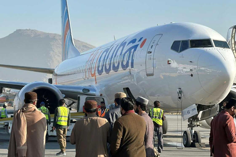 Люди стоят на взлетной полосе рядом с самолетом flydubai после того, как он приземлился в аэропорту Кабула в ноябре 2023 года. Фото: - /AFP/Источник файла: AFP