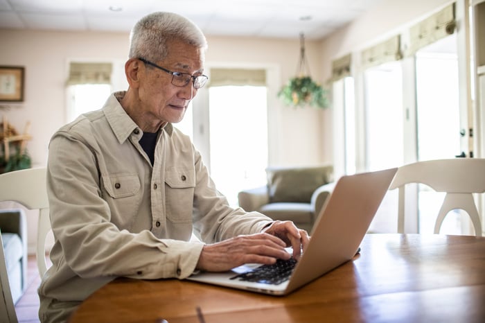 Adult typing on laptop computer.