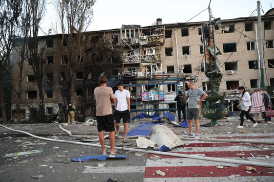 Ukrainian residents stand near their destroyed home following a Russian airstrike in Zaporizhzhia (AP)