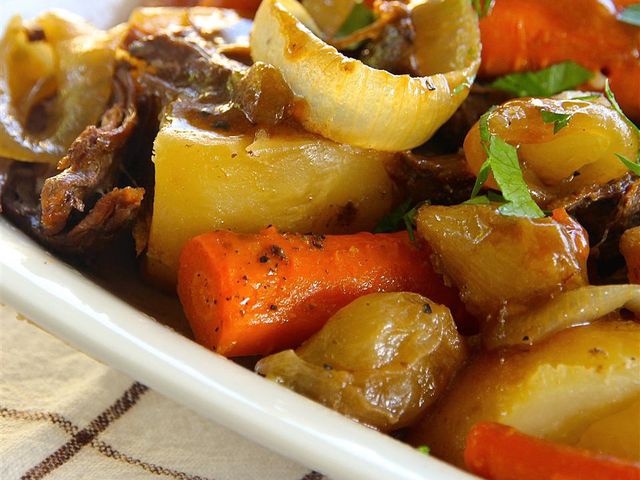 closeup of a serving of My Favorite Pot Roast with chunks of carrot, potato, and onion with rich-looking beef gravy