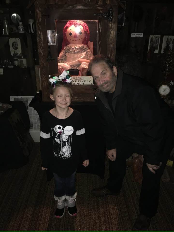 Il marito di Judy, Tony Spera, con la vera Annabelle, nel museo dei Warren, con una bambina che aveva espresso il desiderio di vedere la bambola dal vivo.