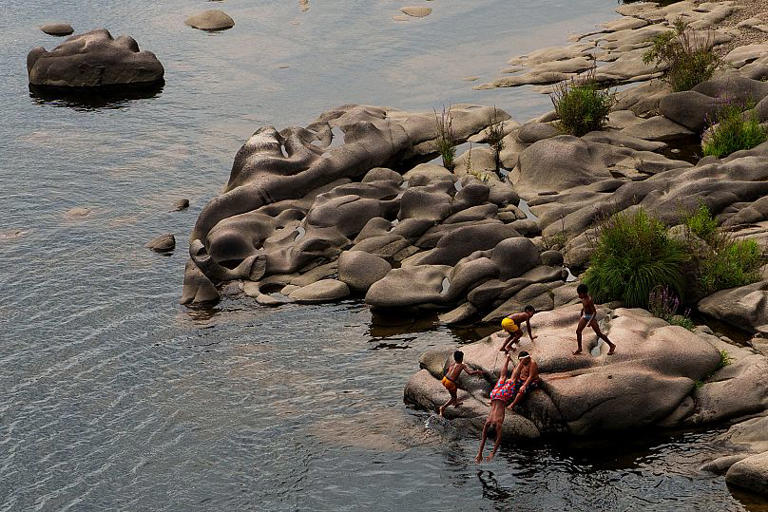Niños se refrescan en el río Mino en Ourense, 30 de agosto de 2024 AP Photo