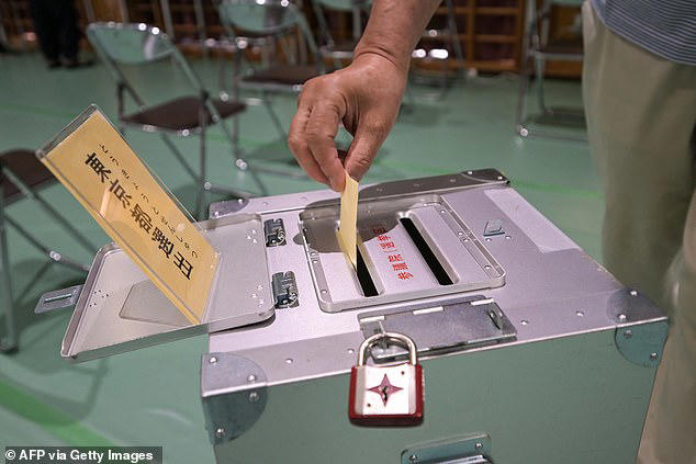 A voter casts their ballot in upper house elections at a polling station in Tokyo on July 20, 2025