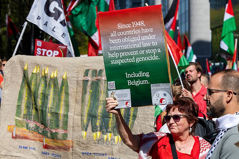 Una mujer sostiene una pancarta mientras marcha durante la manifestación Línea Roja por Gaza en el centro de Bruselas, domingo 7 de septiembre de 2025. AP Photo/Geert Vanden Wijngaert