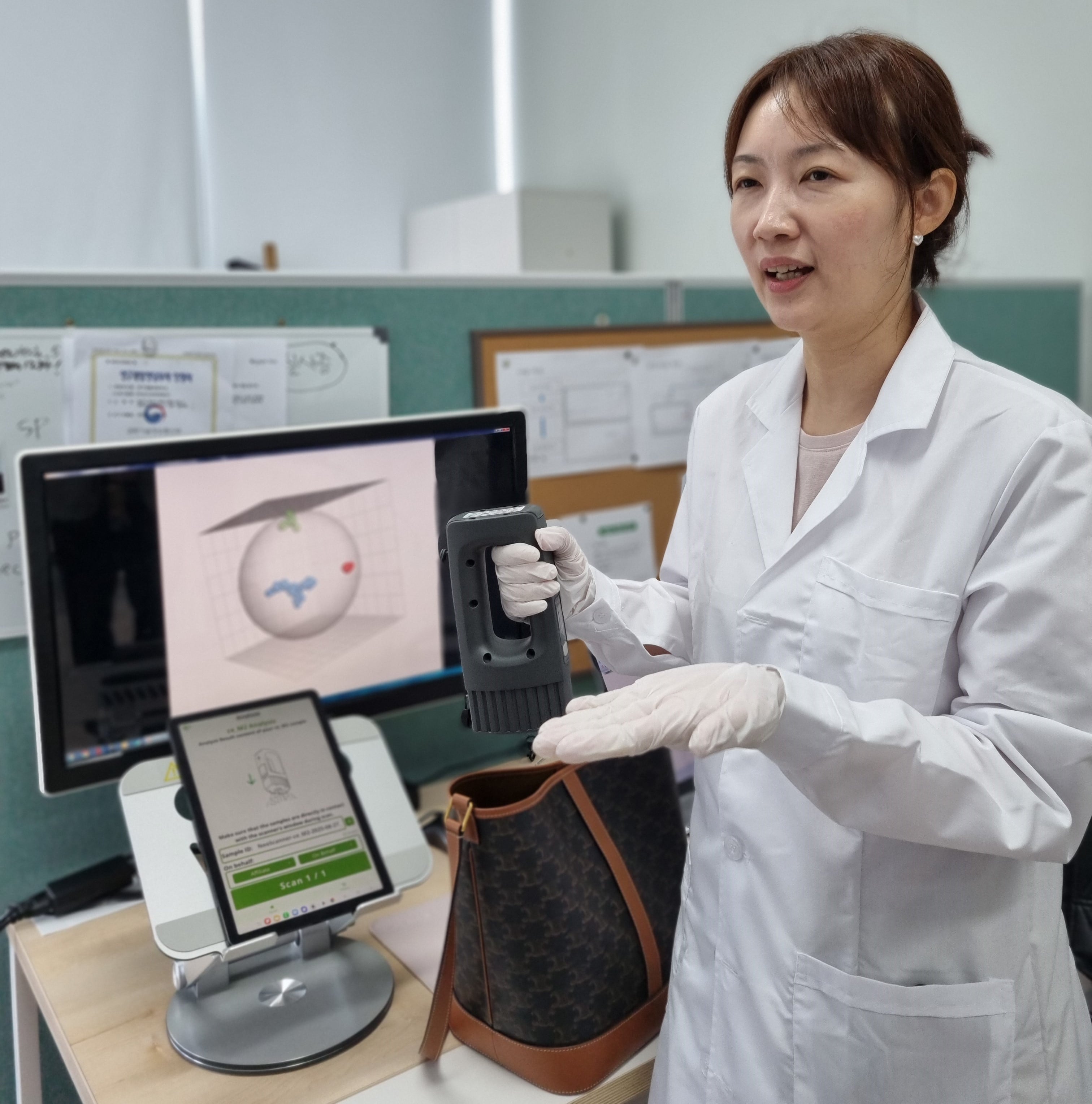 27-го числа исследователь представляет портативное устройство для проверки предметов роскоши в центре инспекции подержанных предметов роскоши на рынке Бунджанг в Сондонгу, Сеул. Когда устройство приближается к продукту, оно анализирует компоненты для определения подлинности. /Предоставлено Чхве Ари