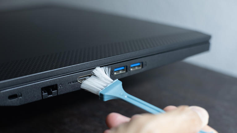 cleaning a computer's USB ports with a brush