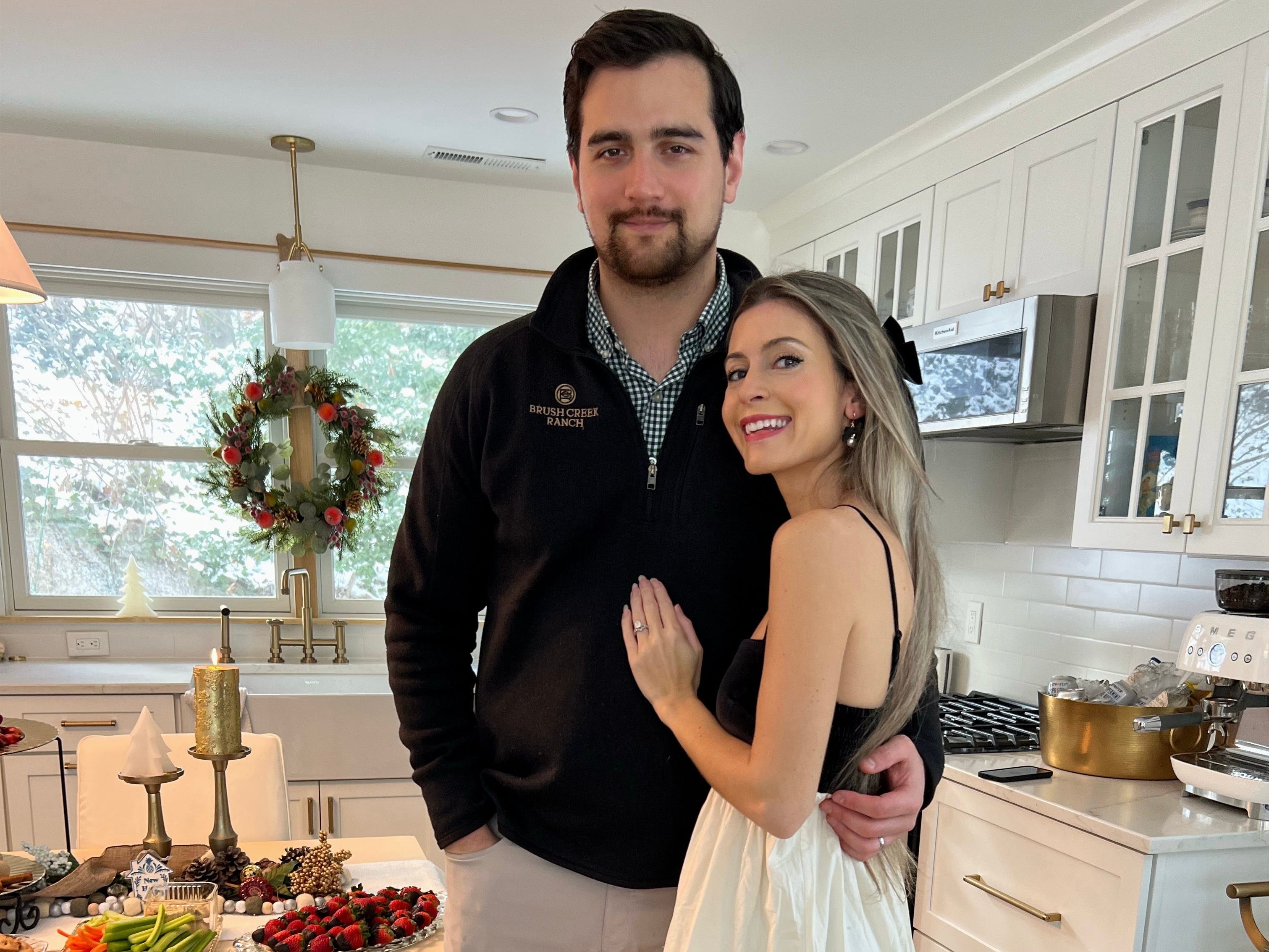 Alexa Mellardo and her husband smiling in their home at Christmastime