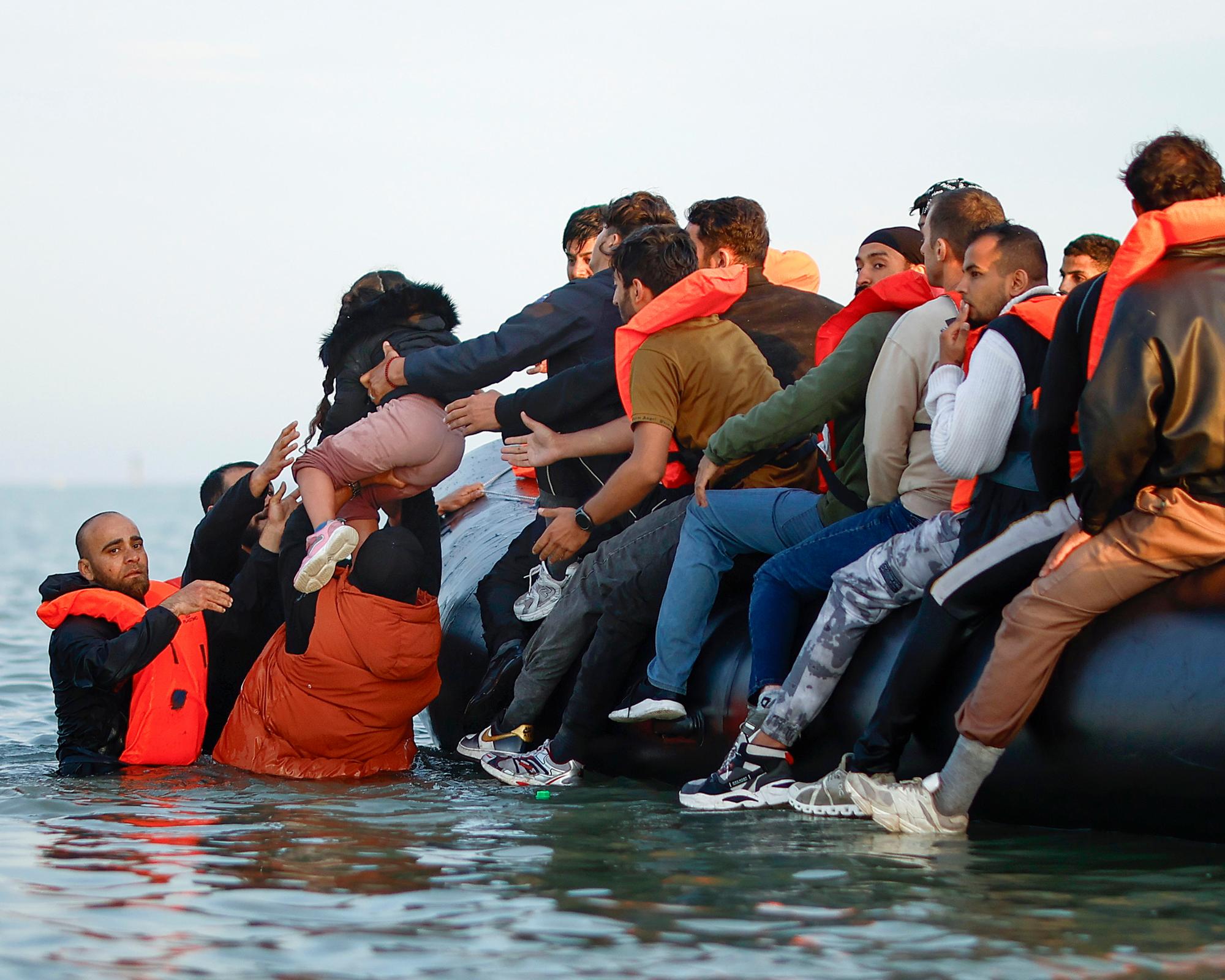 A young girl is lifted aboard an inflatable dinghy to cross the Channel from Gravelines, northern France. Photograph: Yoan Valat/EPA
