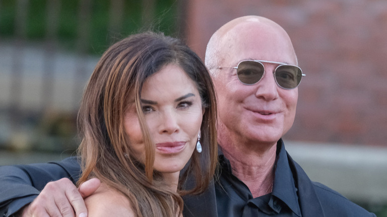 Lauren Sánchez and Jeff Bezos walking together outdoors