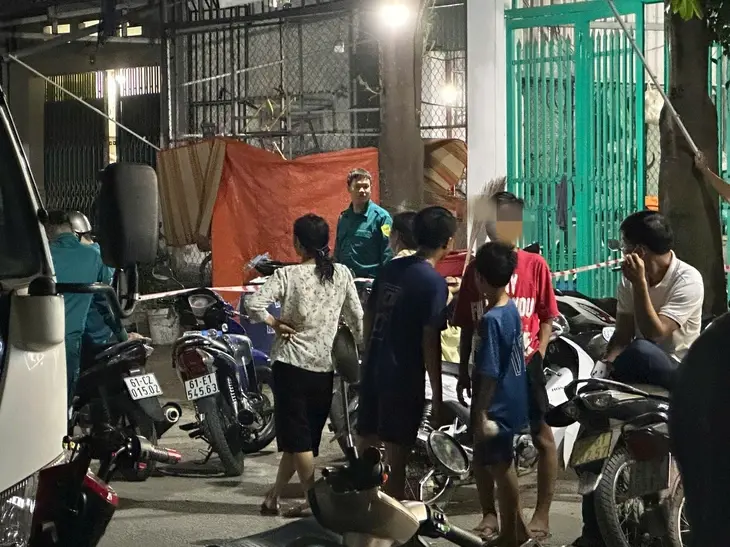 Người dân đứng theo dõi trước căn nhà nơi xảy ra vụ việc - Ảnh: BÁ SƠN