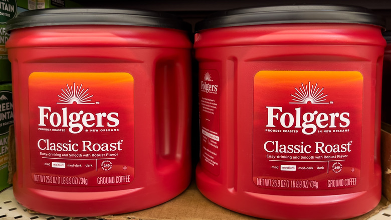 two Folgers plastic coffee containers on a store shelf