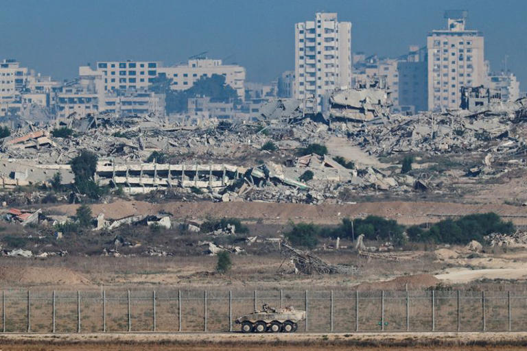 An Armored Personnel Carrier manoeuvres along the Israeli side of the border, as destruction in Gaza is seen in the background, in Israel September 16, 2025. REUTERS/Amir Cohen
