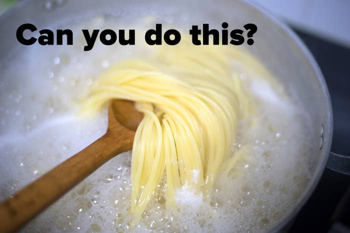 Pasta being cooked in boiling water, stirred with a wooden spoon in a pot