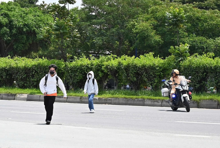 Hai sinh viên băng qua đường sai luật, CSGT yêu cầu đi vào bên vỉa hè để xử lý. Ảnh: Hồ Đinh