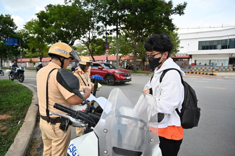 Nam sinh viên bị CSGT xử phạt vì đi bộ sai quy định. Ảnh: Hồ Đinh