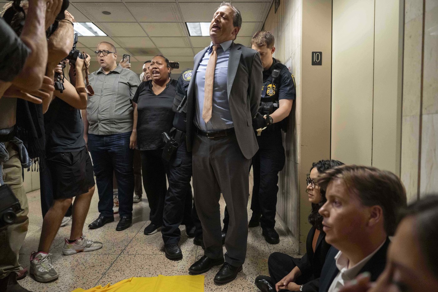 A federal agent detains New York City Comptroller Brad Lander and other elected officials after they demanded access to the inspect the detainment facility at immigration court at the Jacob K. Javits federal building, Thursday, Sept. 18, 2025, in New York. (AP Photo/Yuki Iwamura)