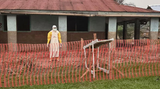 A man wearing protective clothing stands outside an Ebola treatment center in the remote Bulape Health Zone, Kasaï province, DR Congo, Sunday, Sept 7, 2025