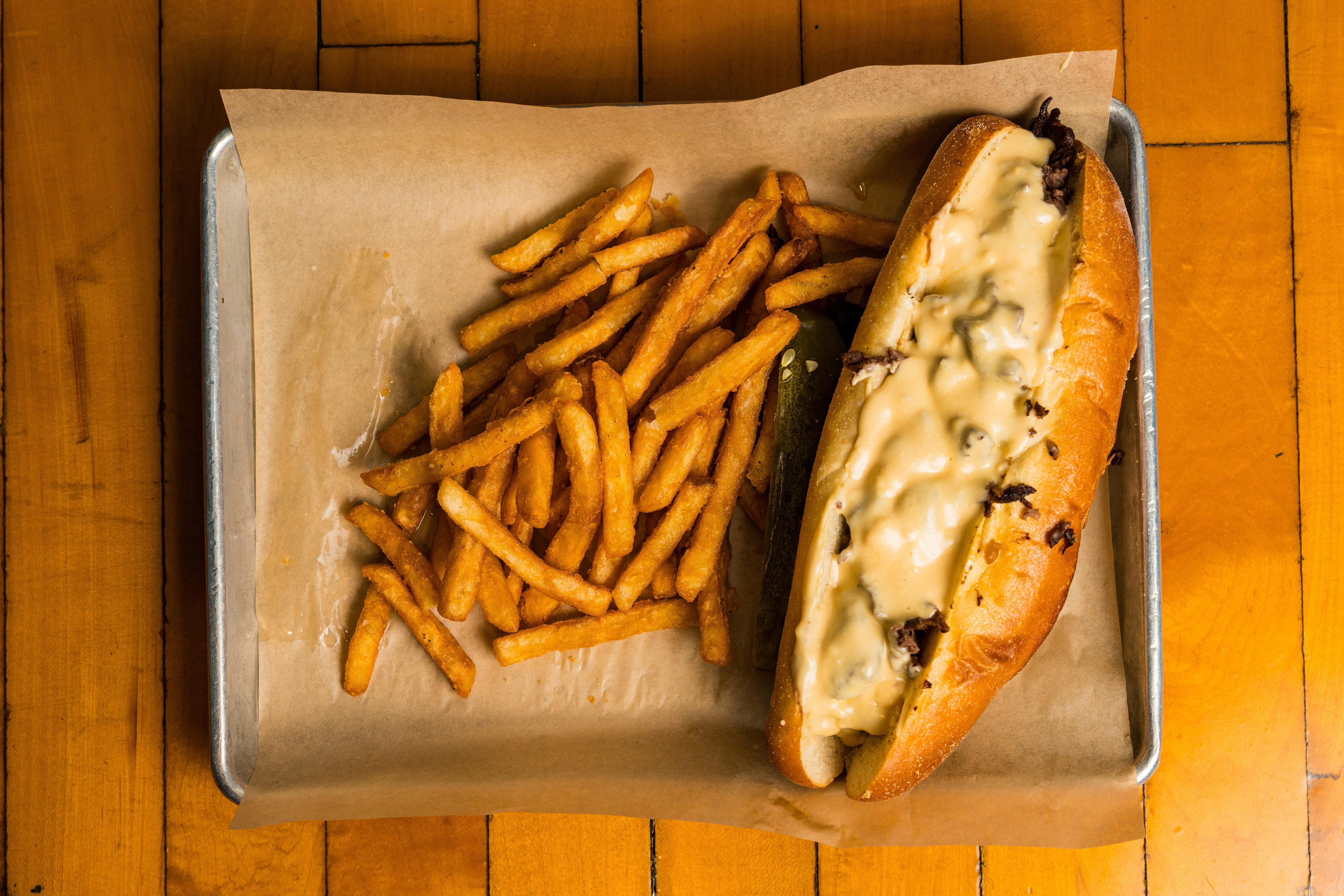 Cheesesteak on tray with fries