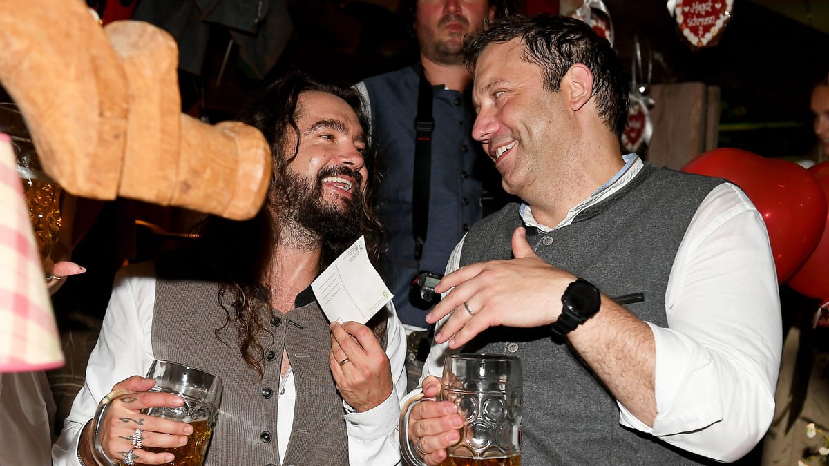 Tom Kaulitz (links) und SPD-Politiker Lars Klingbeil (rechts) im Käferzelt: Zwischen Maßkrügen kommt es beim Oktoberfest in München zu einer gelösten Begegnung. (Quelle: Felix Hörhager/dpa/dpa)