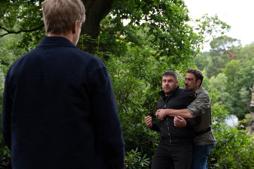 Emmerdale's Robert looks on as John drags Aaron over a cliff