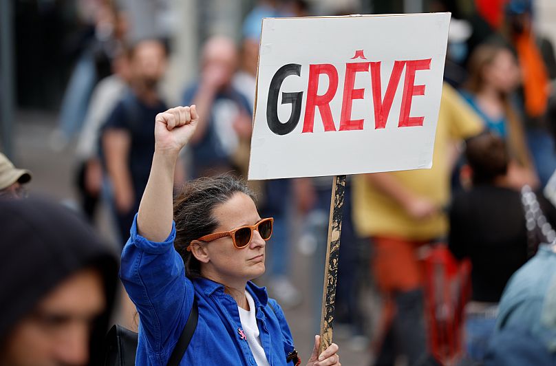 A protester holds a placard that reads "strike" during a rally of the "Block Everything" movement in Lille, 10 September, 2025 AP Photo