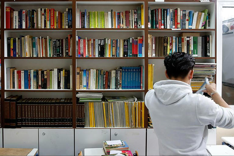 File: An inmate takes a book from a prison library AP Photo 2021