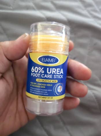 Hand holding a foot care stick labeled