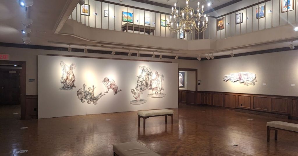 A bi-level art gallery with a seating area.
