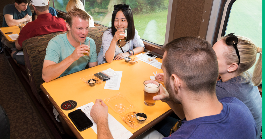 Four people are seated at a table on a train.