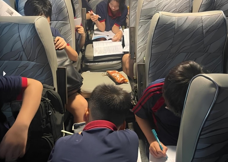 Các học sinh trường con chị Hồng ngồi làm bài tập trên xe trong lúc tắc đường, từ trường về nhà, tối 30/9. Ảnh: Nhân vật cung cấp