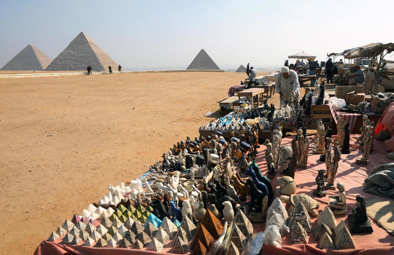 epa12404898 (FILE) - A souvenir vendor works in front of the Giza Pyramids, in Giza, Egypt, 10 November 2020 (reissued 25 September 2025). World Tourism Day is an annual international observance celebrated on the 27 September to highlight the social, cultural, economic, and political significance of tourism worldwide. The tourism industry faces several major global challenges as well, including economic and political instability, environmental concerns as well as high pressure on local infrastructures and housing in popular destinations. EPA/KHALED ELFIQI *** Local Caption *** 56488893