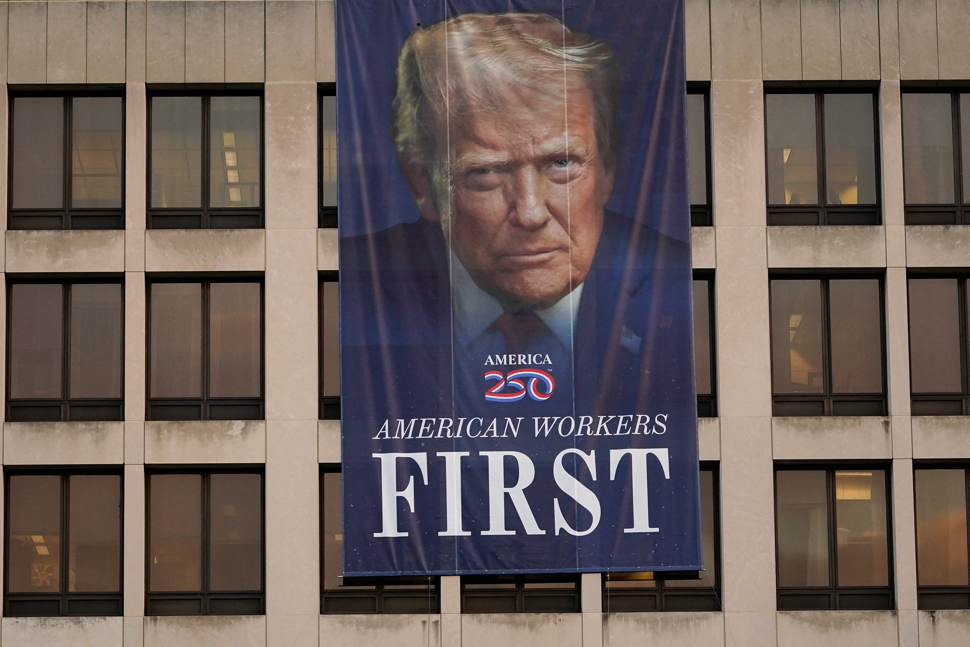 A banner depicting U.S. President Donald Trump hangs on a building on the first day of a partial government shutdown in Washington, D.C., U.S., October 1, 2025.