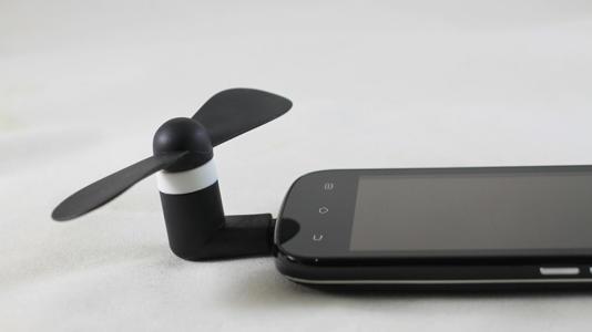 mini USB fan plugged into a phone's USB port