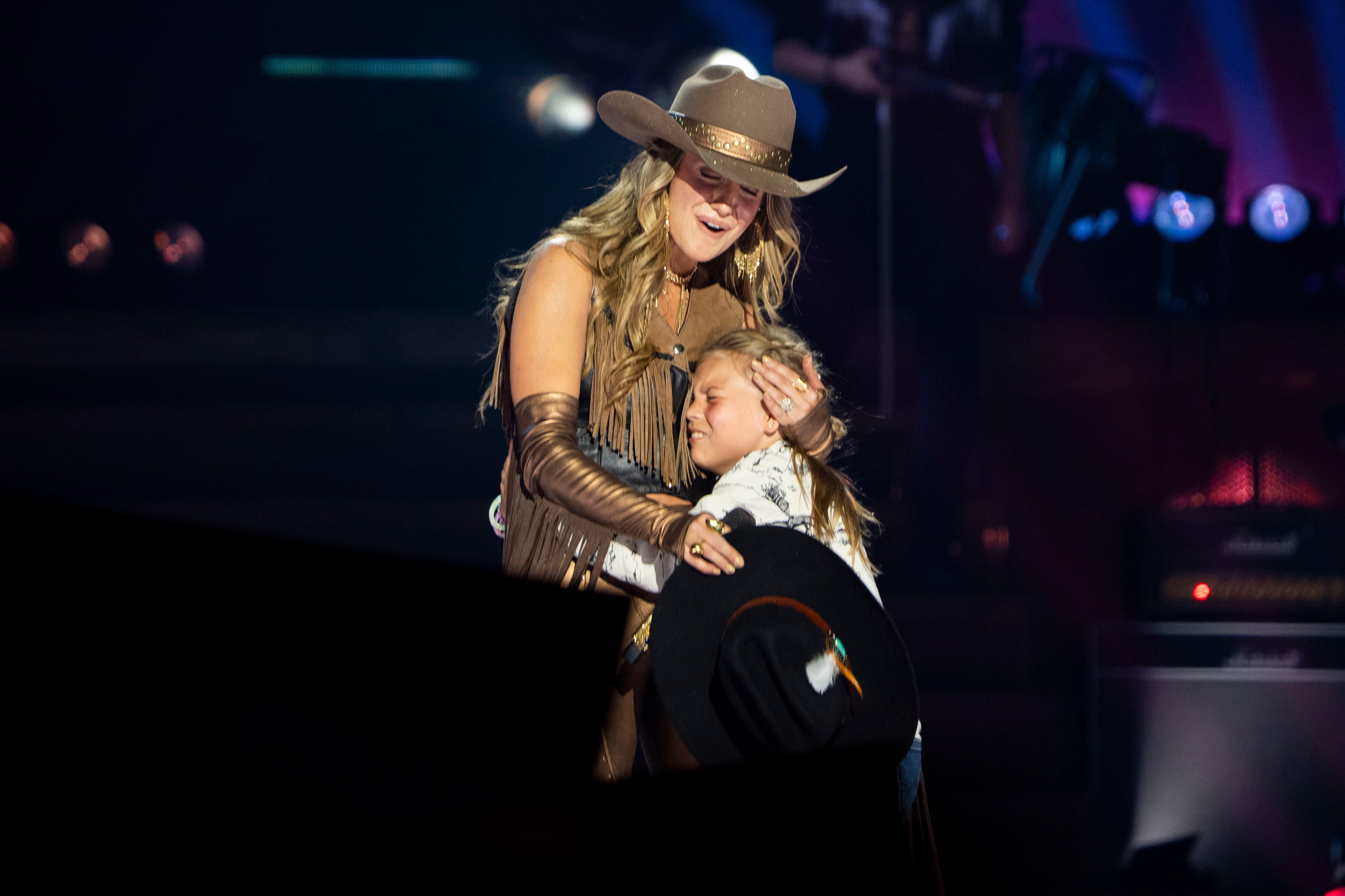 Lainey Wilson hugs a young fan on stage during her performance at Bridgestone Arena in Nashville, Tenn., Thursday, Oct. 2, 2025.